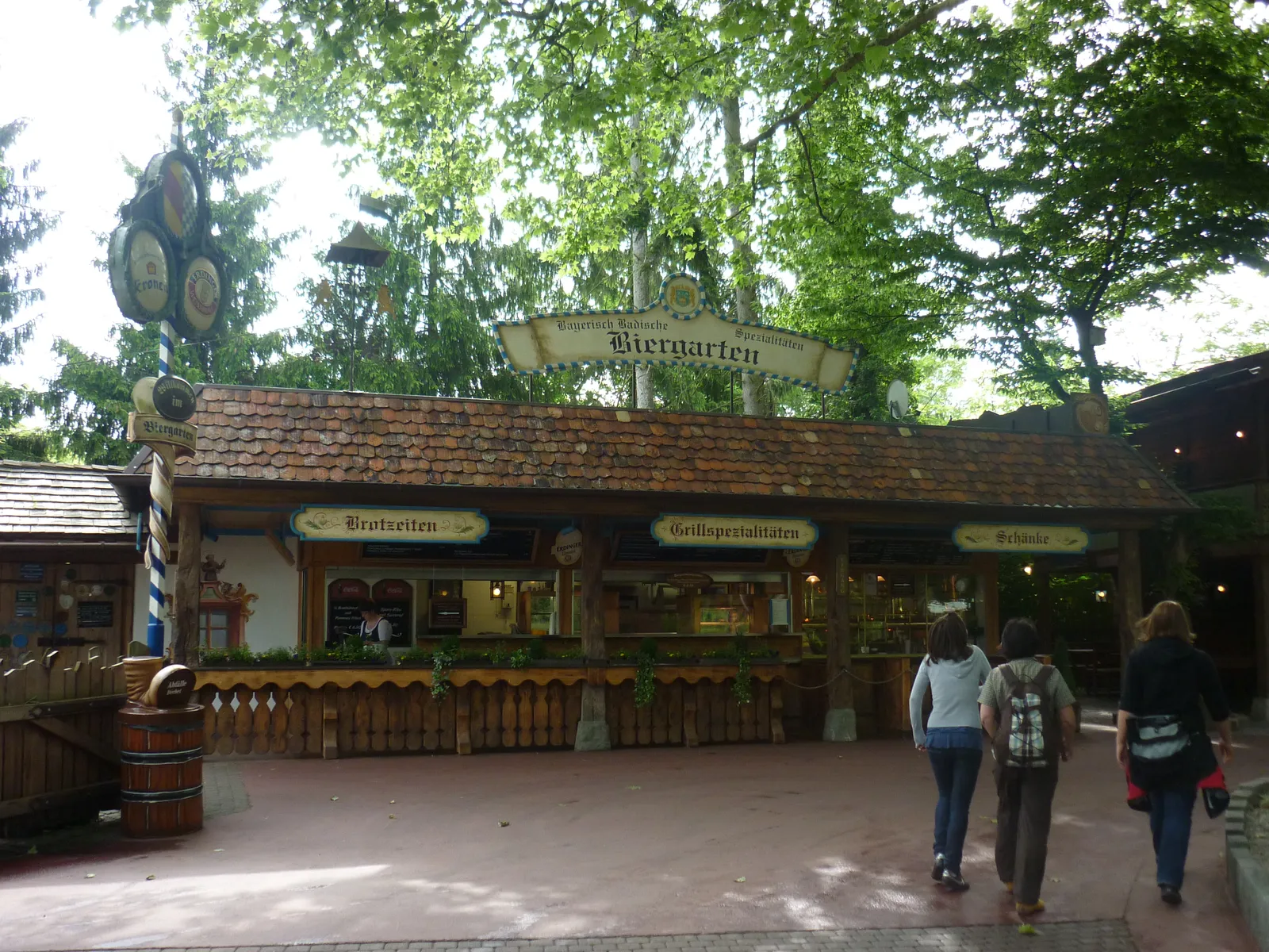 Biergarten mit Holzbude und Bierfass unter Bäumen