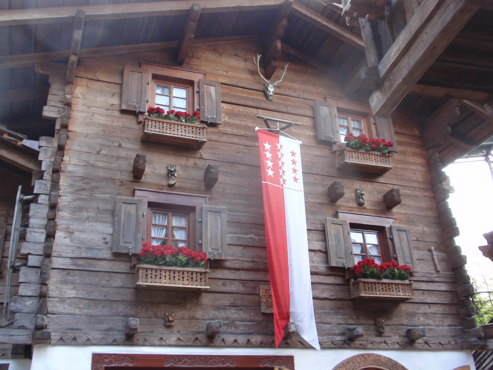 Holzchalet mit roten Geranien