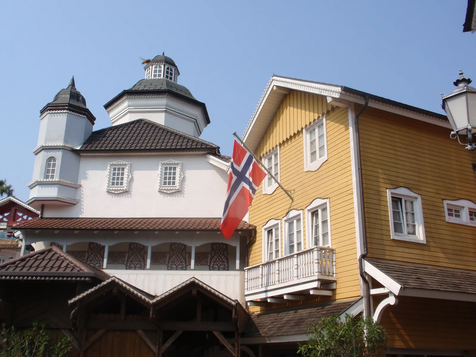 Gelbes Holzhaus und weißer Turm im skandinavischen Themenbereich